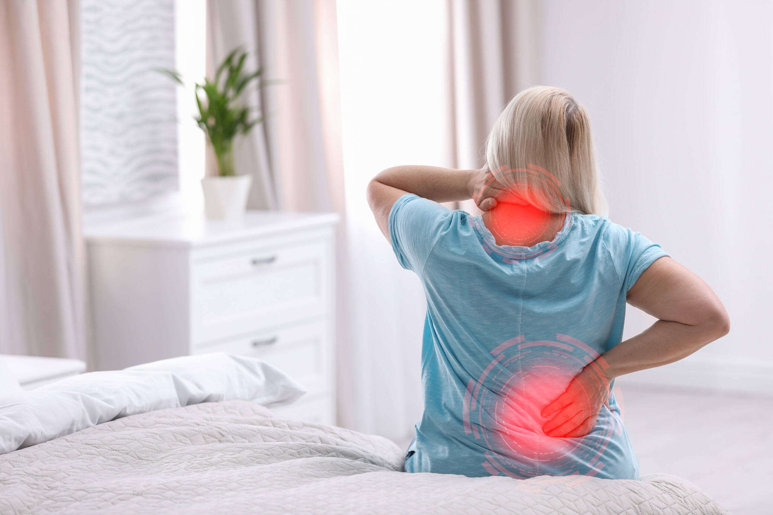 Woman suffering from back pain after sleeping on uncomfortable m